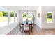 Bright dining room featuring four windows, modern chandelier, table with seating for six, and light wood flooring at 2133 Tite Rd, Stanfield, NC 28163