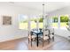 Bright dining room with four windows, modern chandelier, table with seating for six, and light wood flooring at 2133 Tite Rd, Stanfield, NC 28163