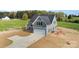 A charming two-story home features a pristine garage, complemented by a well-manicured lawn and a concrete driveway at 2133 Tite Rd, Stanfield, NC 28163