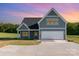 Gray two-story home with an attached two-car garage, concrete driveway, and green grass in the front yard at 2133 Tite Rd, Stanfield, NC 28163