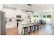 A bright white kitchen with island seating, stainless steel appliances, and an eat-in dining area at 2133 Tite Rd, Stanfield, NC 28163
