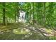 Landscaped backyard featuring a fire pit and surrounded by lush trees for privacy at 2417 Labelle Dr, Waxhaw, NC 28173