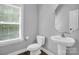 Charming half bathroom with pedestal sink, octagon mirror and wood look floor at 2417 Labelle Dr, Waxhaw, NC 28173