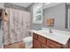 Well-lit bathroom featuring a vanity, toilet, and shower with floral curtain at 2417 Labelle Dr, Waxhaw, NC 28173