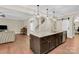 Kitchen island with granite countertop, dark wood cabinets, and stainless steel dishwasher at 2417 Labelle Dr, Waxhaw, NC 28173