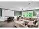Cozy living room features a large projector screen, wood floors, and natural light at 2417 Labelle Dr, Waxhaw, NC 28173