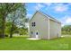 Back exterior view of home with a well maintained lawn and a bright blue sky at 3056 Goble St, Gastonia, NC 28056