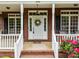 Close-up of a charming brick home's front porch with decorative wreath and vibrant floral arrangements at 3179 Westview Rd, Concord, NC 28025