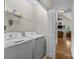 Laundry room equipped with washer, dryer, and shelving with doorway to the living room at 3179 Westview Rd, Concord, NC 28025