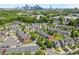 Aerial view of townhomes with surrounding green spaces and a city skyline in the distance at 3245 Major Samuals Way, Charlotte, NC 28208