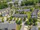 Aerial view features a neighborhood of townhomes with mature trees and manicured green spaces at 3245 Major Samuals Way, Charlotte, NC 28208