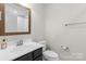 Bathroom with white sink and toilet, and a wood-framed mirror at 3245 Major Samuals Way, Charlotte, NC 28208
