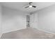 Bedroom with a ceiling fan and connecting hallway featuring neutral colors at 3245 Major Samuals Way, Charlotte, NC 28208