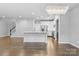 Bright living area with hardwood floors, white walls, modern chandelier, and open to the kitchen at 3245 Major Samuals Way, Charlotte, NC 28208