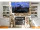 Cozy living room featuring a stone fireplace with built-in shelving and a mounted TV at 3300 Paul Heavner Ln, Lincolnton, NC 28092