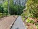 Backyard with stone bordered path and lush landscaping on the edge of a wooded area at 3519 Weddington Oaks Dr, Matthews, NC 28104