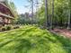 Large backyard featuring a manicured lawn and mature trees, creating a serene and private outdoor space at 3519 Weddington Oaks Dr, Matthews, NC 28104