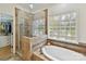 Bathroom boasting glass shower, soaking tub, and window with a view of greenery at 3519 Weddington Oaks Dr, Matthews, NC 28104
