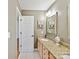 Bathroom featuring a single vanity with granite countertop, a large mirror, and stylish lighting fixtures at 3519 Weddington Oaks Dr, Matthews, NC 28104
