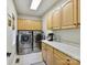 Bright laundry room featuring stainless steel washer/dryer, marble counters, and ample cabinet storage space at 3519 Weddington Oaks Dr, Matthews, NC 28104