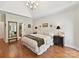 Main bedroom showcasing hardwood floors, tray ceiling, and ensuite bathroom entrance at 3519 Weddington Oaks Dr, Matthews, NC 28104
