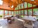 Bright sunroom with wood vaulted ceilings, large windows offering wooded views and a comfortable seating area and dining table at 3519 Weddington Oaks Dr, Matthews, NC 28104