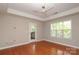 Bright bedroom featuring gleaming hardwood floors, balcony access, ceiling fan, and large window at 3937 Arbor Ln # H, Charlotte, NC 28209