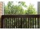 Charming deck with wooden railings offers a tranquil view of lush green trees and foliage at 3937 Arbor Ln # H, Charlotte, NC 28209