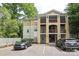 Exterior view of a condo building with ample parking and attractive architectural details at 3937 Arbor Ln # H, Charlotte, NC 28209