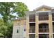 Multi-story building with charming balconies, complemented by lush green trees, offering serene outdoor living at 3937 Arbor Ln # H, Charlotte, NC 28209