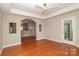Open-concept living room with hardwood floors, open archways, and access to the kitchen and balcony at 3937 Arbor Ln # H, Charlotte, NC 28209
