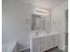 Bathroom featuring double sinks with modern fixtures and white cabinets at 4018 Larkhaven Village Dr, Charlotte, NC 28215
