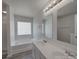 Bright bathroom featuring double sink vanity and a soaking tub with a glass block window at 4018 Larkhaven Village Dr, Charlotte, NC 28215