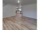 Open-concept living area with laminate flooring and a view of the modern kitchen, offering a bright and airy space at 4018 Larkhaven Village Dr, Charlotte, NC 28215