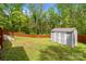 View of the home's back yard with a wooden fence, lush grass, and a shed at 4050 Leafmore St, Concord, NC 28027