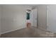 A gray bedroom with a doorway opening to another room with hardwood floors at 4050 Leafmore St, Concord, NC 28027
