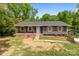 Charming single story home with a brick foundation, gray siding, and lovely wood shutters at 4050 Leafmore St, Concord, NC 28027