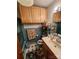 A functional bathroom features wood cabinets, blue tiling, and a patterned floor at 406 S Caldwell Ave, Newton, NC 28658