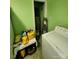 Laundry room featuring green walls, laminate floor, laundry appliances, and shelving for supplies at 406 S Caldwell Ave, Newton, NC 28658
