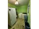 Bright laundry room featuring painted green walls, utility appliances, and laminate floors at 406 S Caldwell Ave, Newton, NC 28658