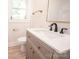 Bright bathroom with a modern vanity, stylish mirror, and neutral-colored walls and tile at 451 S Strand Dr, Norwood, NC 28128