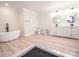 Bright bathroom features modern tub, toilet and double sink vanity with designer gold framed circular mirrors at 451 S Strand Dr, Norwood, NC 28128
