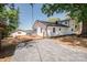 Exterior view of a white lake house with a gravel driveway, storage shed, and an air conditioning unit at 451 S Strand Dr, Norwood, NC 28128