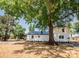 Side and rear exterior view of a lake house featuring a lush tree, and stairs down to the yard at 451 S Strand Dr, Norwood, NC 28128