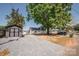 Exterior view of a lake house with gravel driveway, shed, and green space, blending comfort and convenience at 451 S Strand Dr, Norwood, NC 28128