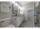 Bathroom with granite countertops, dual sinks, white cabinets, modern fixtures, and an open doorway at 504 Gardenbrook Trl, Belmont, NC 28012