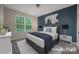This bedroom features a queen bed, stylish décor, and a large window for natural light at 504 Gardenbrook Trl, Belmont, NC 28012