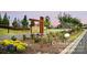 Community entrance featuring stone accents, manicured landscaping, vibrant yellow flowers, and neighborhood signage at 504 Gardenbrook Trl, Belmont, NC 28012
