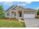 Beautifully crafted home featuring a stone-accented entrance, two-car garage, and inviting curb appeal at 504 Gardenbrook Trl, Belmont, NC 28012