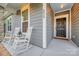 Charming front porch featuring rocking chairs, stone accents, and a welcoming entrance at 504 Gardenbrook Trl, Belmont, NC 28012